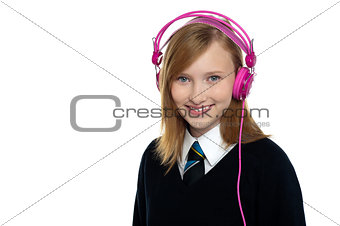 Cute teenager listening to music through headphones