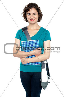 College student with stylish sling bag and notebook