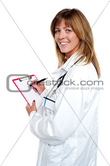 Beautiful smiling physician writing prescription