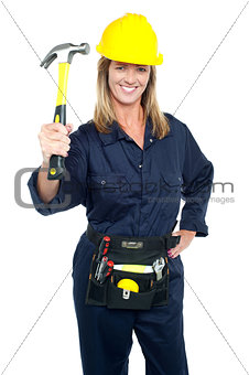 Female construction worker holding up hammer