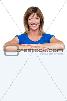 Happy woman standing behind whiteboard