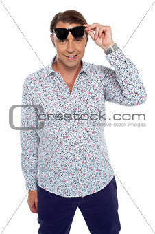 Confident casual man taking off his dark shades