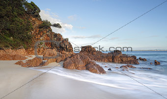 Morning light glistens on the volcanic rocks at Shoal Bay