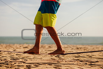 teenage balancing on slackline with sea view