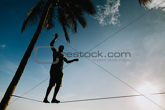 teenage balancing on slackline with sky view