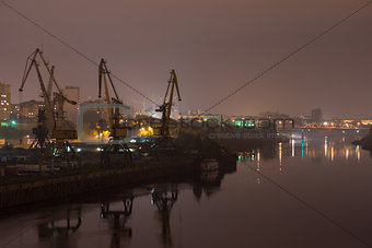 Industrial area with river port. Behind the houses, in front of water
