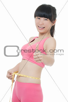 Fit Asian woman measuring her waist on white