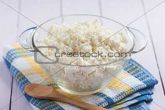 Cottage cheese in a glass with a wooden spoon, close-up, selecti