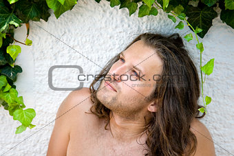 thinking man looking on green leaves