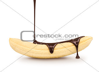 dark chocolate is poured on the ripe banana on a white backgroun