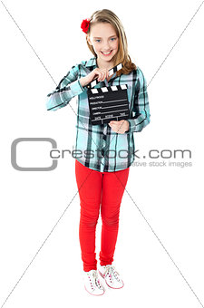 Smiling girl holding clapperboard