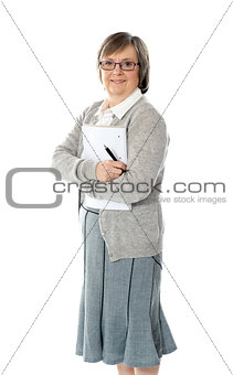 Senior woman holding spiral notepad and pen