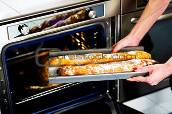 Hands of a woman holding hot baguette