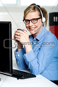 Help desk executive drinking coffee at work
