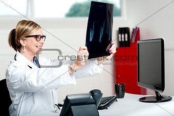 Female doctor looking at x-ray report of patient