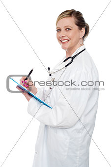 Smiling aged surgeon holding pen and clipboard