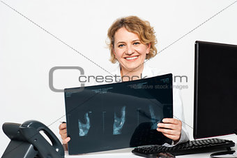 Experienced female surgeon holding x-ray report