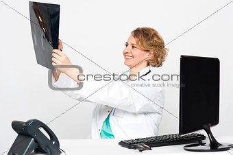 Smiling female surgeon looking at patients x-ray