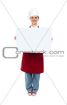 Smiling chef displaying white advertising board