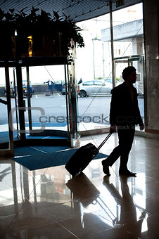 Man entering hotel lobby with his luggage