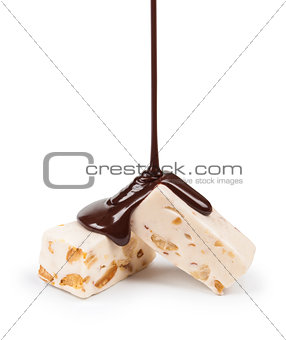 pouring chocolate candy nougat and peanuts on a white background