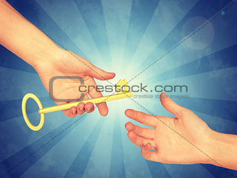 Hand passing a gold key