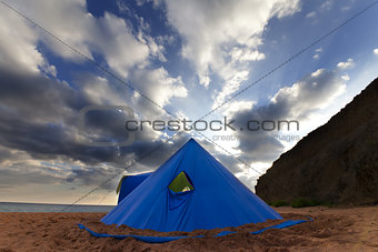 Conical tent on summer beach in evening