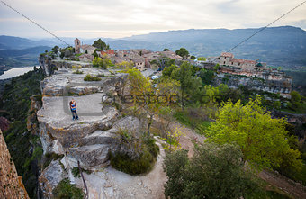 Young couple standing on cliff and enjoying valley view of old village Siurana