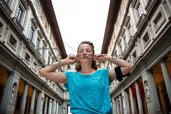 Fitness woman wearing earphones near uffizi gallery in florence,