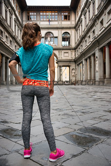 Full length portrait of fitness woman standing in front of uffiz