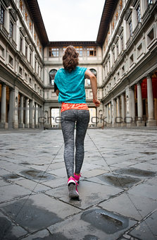 Fitness woman jogging near uffizi gallery in florence, italy. re