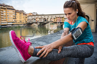 Fitness woman stretching near ponte vecchio in florence, italy