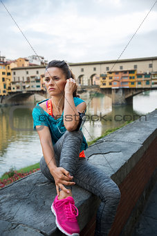 Fitness woman sitting near ponte vecchio in florence, italy and 