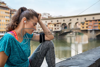 Fitness woman sitting near ponte vecchio in florence, italy