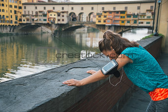 Fitness woman catching breathe in front of ponte vecchio in flor