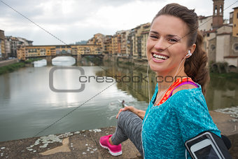Portrait of happy fitness woman in front of ponte vecchio in flo