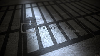 Jail cells bars casting shadows on floor.