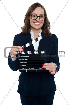 Gorgeous corporate woman holding a clapperboard