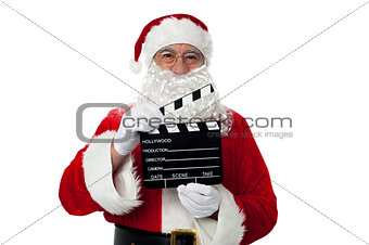 Cheerful aged Santa posing with a clapperboard