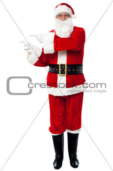 Man in Santa costume indicating at copy space area