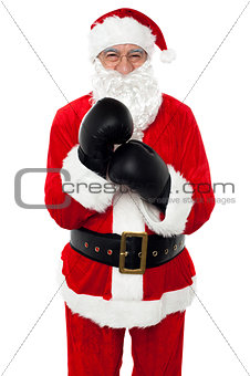 Aged cheerful Santa wearing boxing gloves