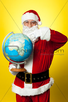 Father Christmas showing his country on globe