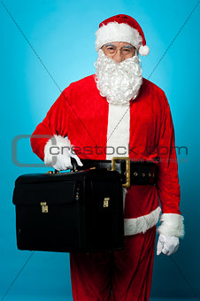 Santa is all set to visit his new office, holding briefcase