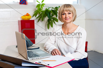 Casual portrait of a woman seated at her work place