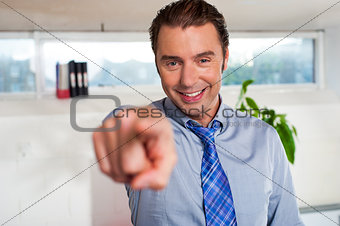 Handsome man in formals pointing at you