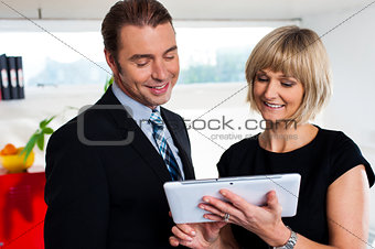 Female secretary showing appointments to boss saved on tablet device