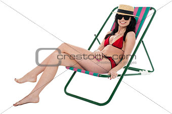Glamorous bikini model relaxing on reclining chair