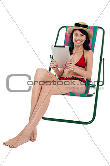 Bikini woman entertaining herself through tablet device