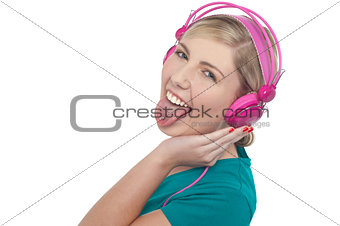 Woman with headphones on sticking her pierced tongue out