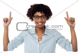 Excited woman pointing upwards